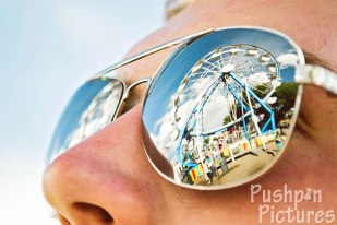 Reflection of a ferris wheel in aviator sunglasses at the Manassa Pioneer Days